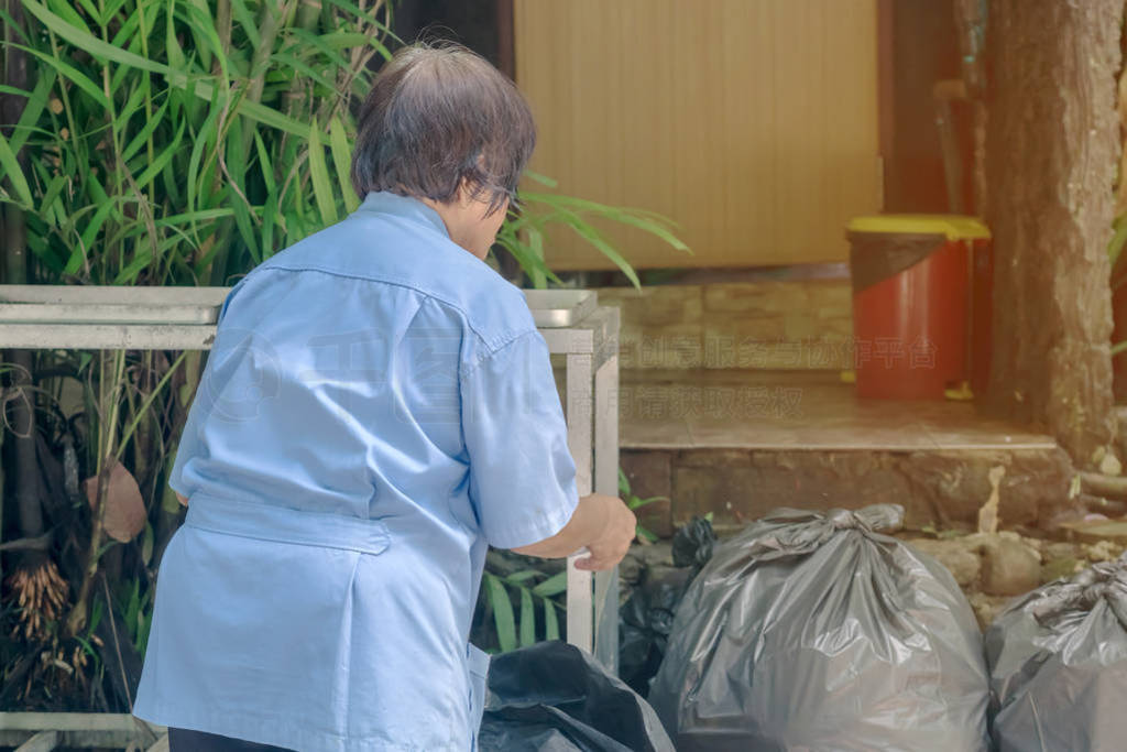 Female worker sort the garbage and packed in black bags for tran