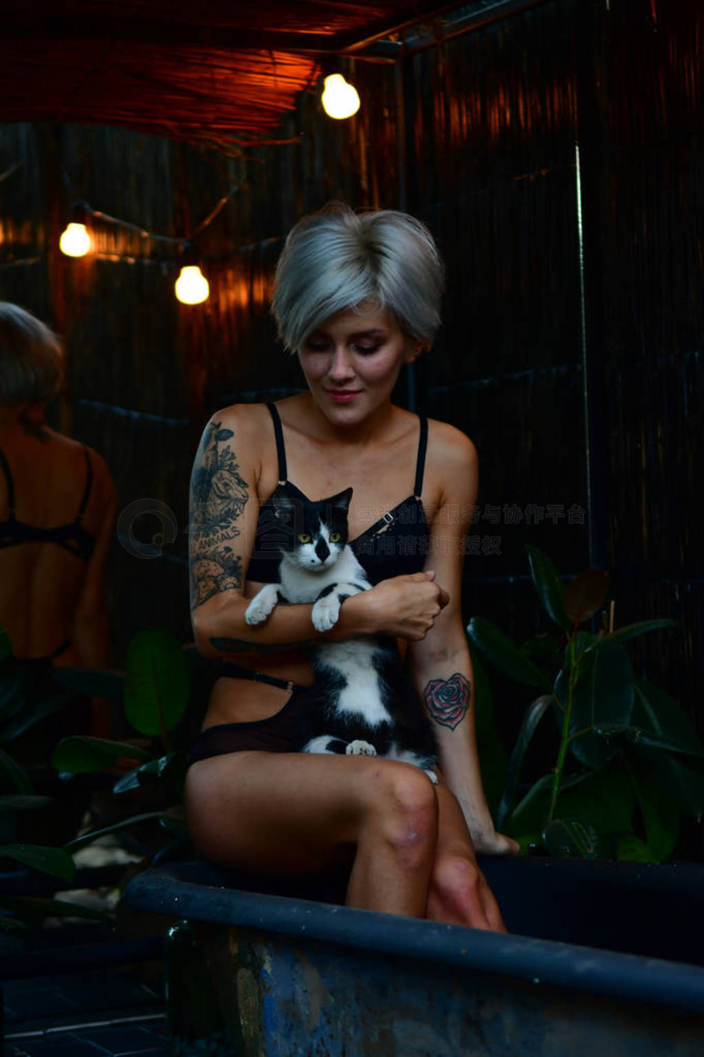 portrait of beautiful young woman sitting in bath holding a cat
