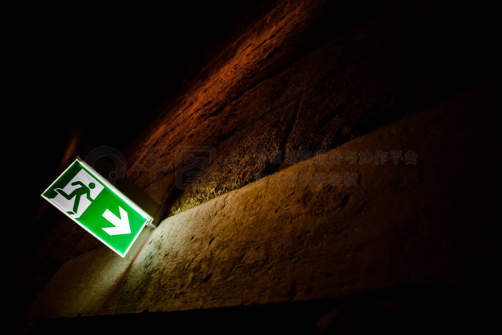 Emergency exit sign illuminated with dark background.