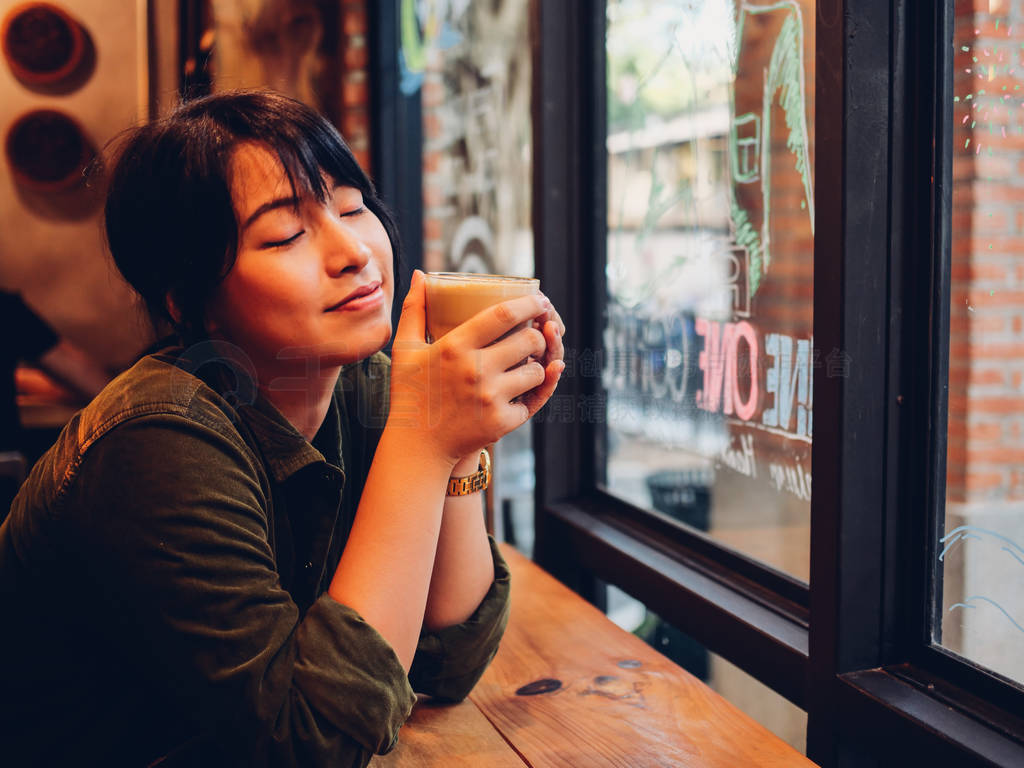 Asian woman drinking coffee in coffee shop cafe