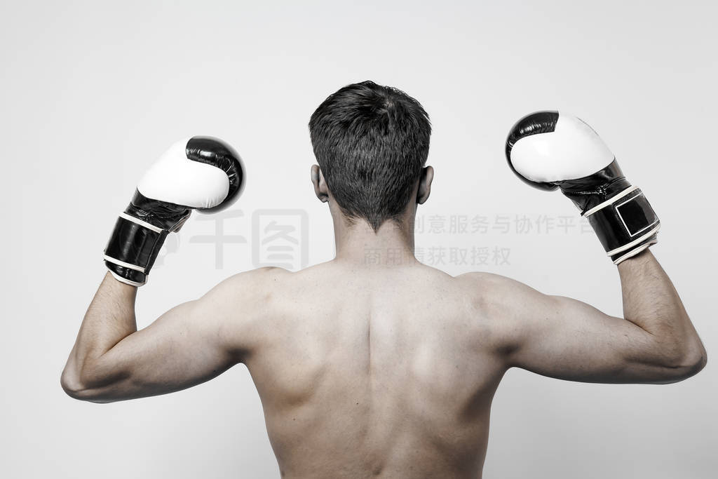 View from the back of a white brunet man raising his arms up in