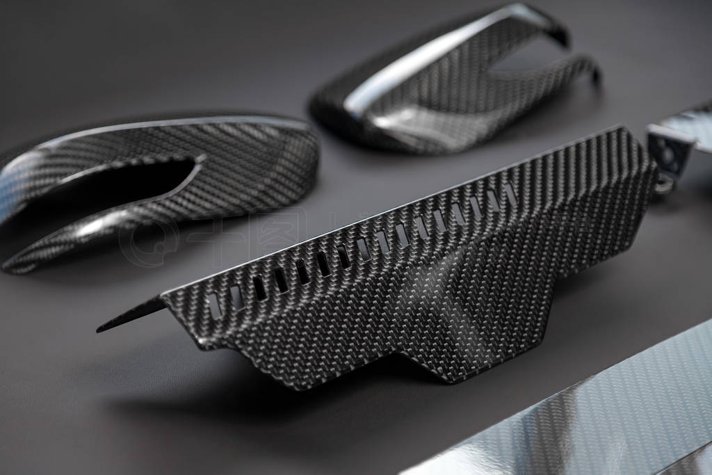 A close-up on a car exterior elements made from carbon fiber of