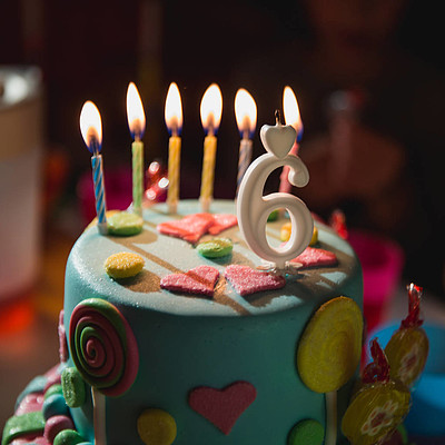生日蛋糕,在黑暗的背景下用燃烧的蜡烛和 i