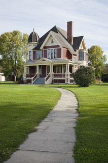 维多利亚时代房子与草坪和人行道上晴朗的下午