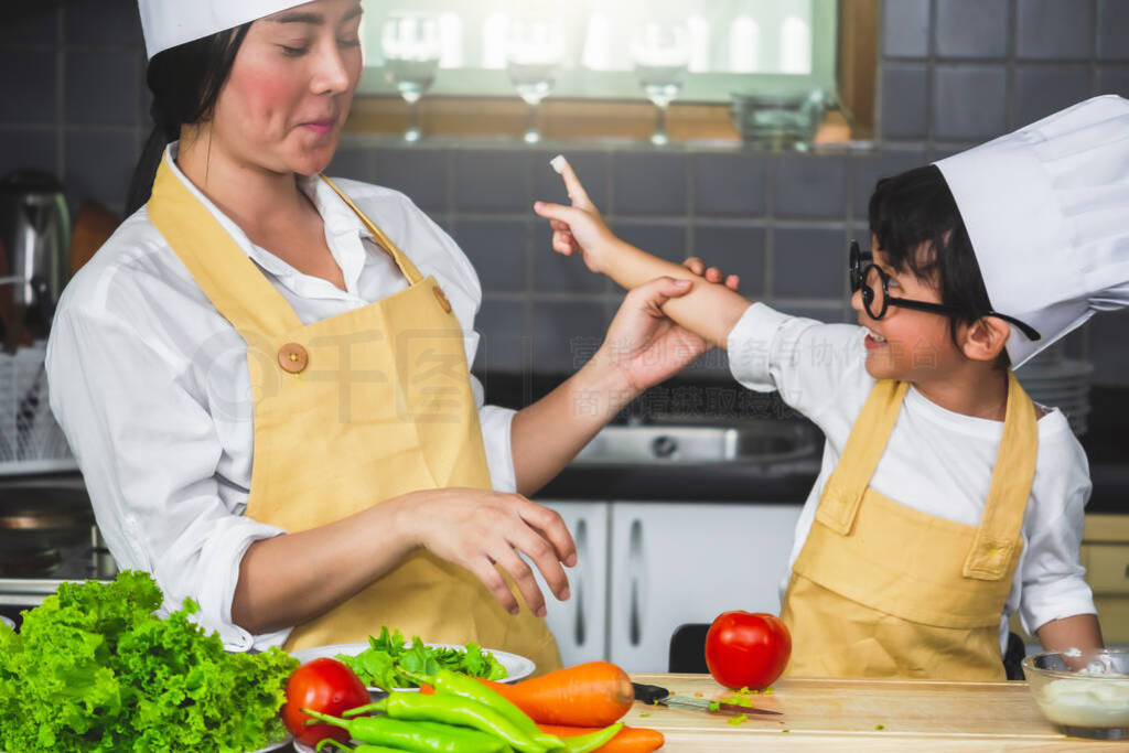 Asian woman young mother with son boy cooking salad mom sliced