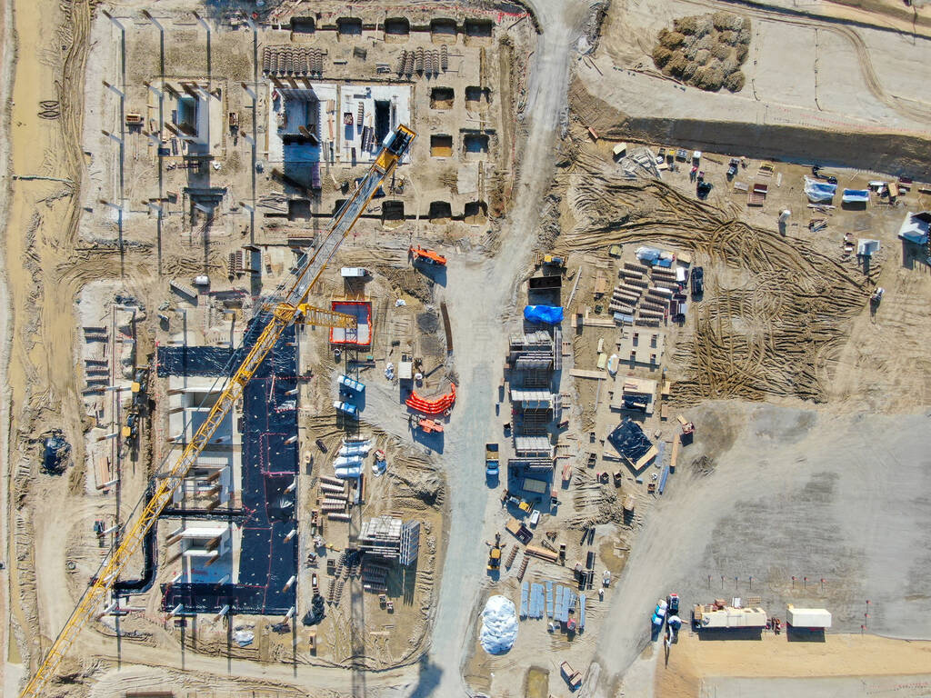 Aerial view of new construction site with crane and building mat