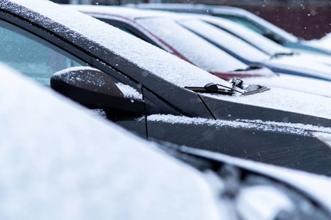 雪覆盖的汽车在停车场关闭。 防冻液没有使用。 雪地里的车辆。 冬天的时间来了。 恶劣天气条件