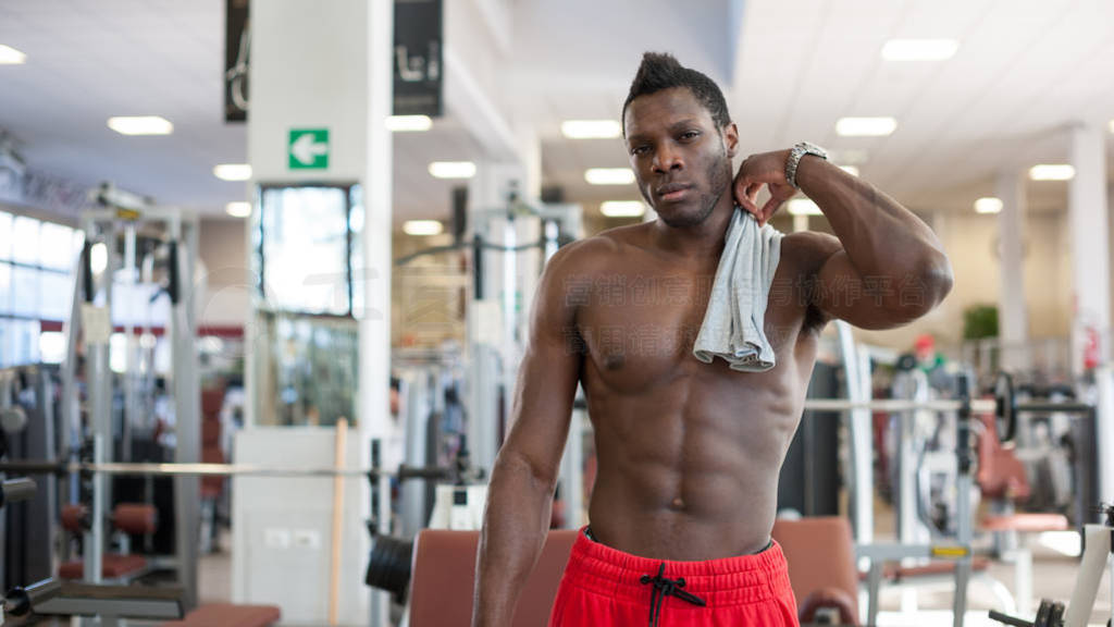 Strong black man having a pause in the gym.