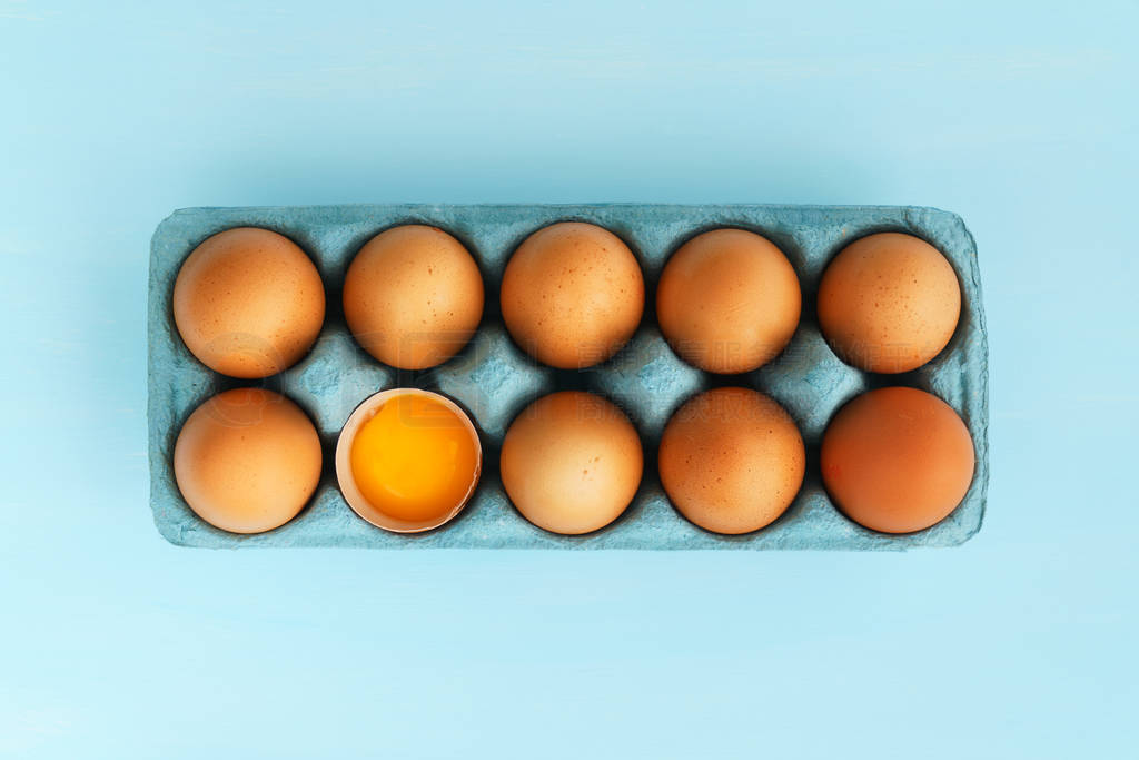 Close-up view of raw organic chicken eggs in a blue carton box.