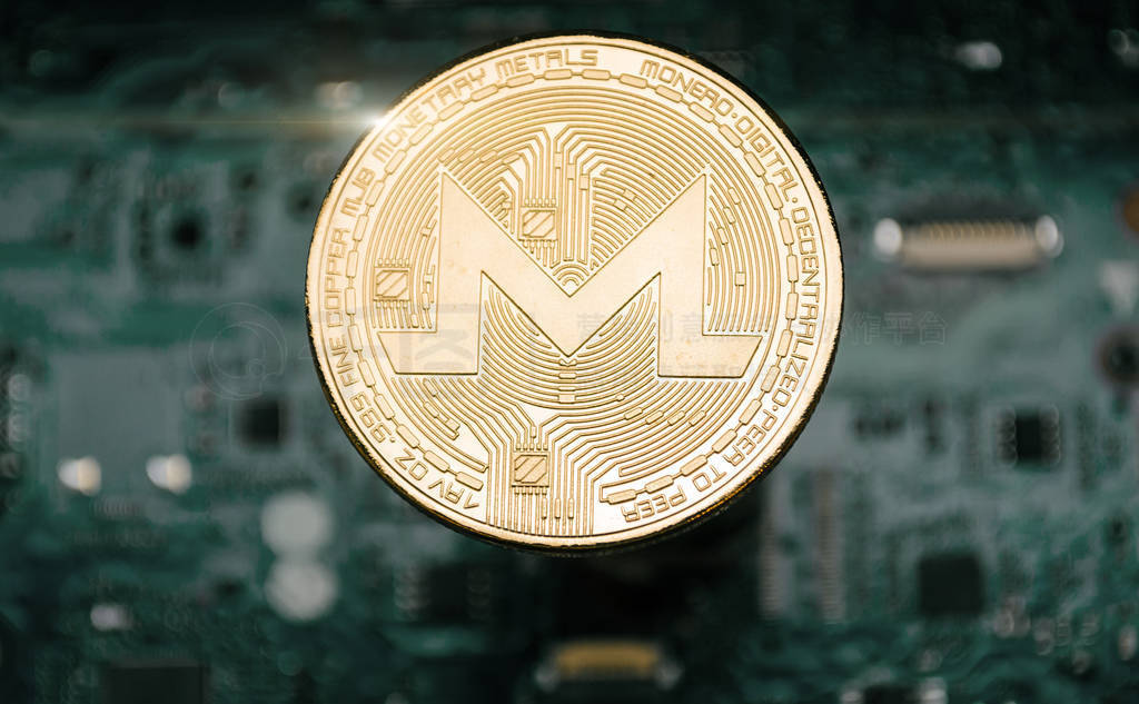 Gold monero coin, on background of computer motherboard.