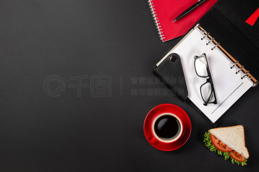 Elegant black office desktop with laptop, cup of coffee and a sa