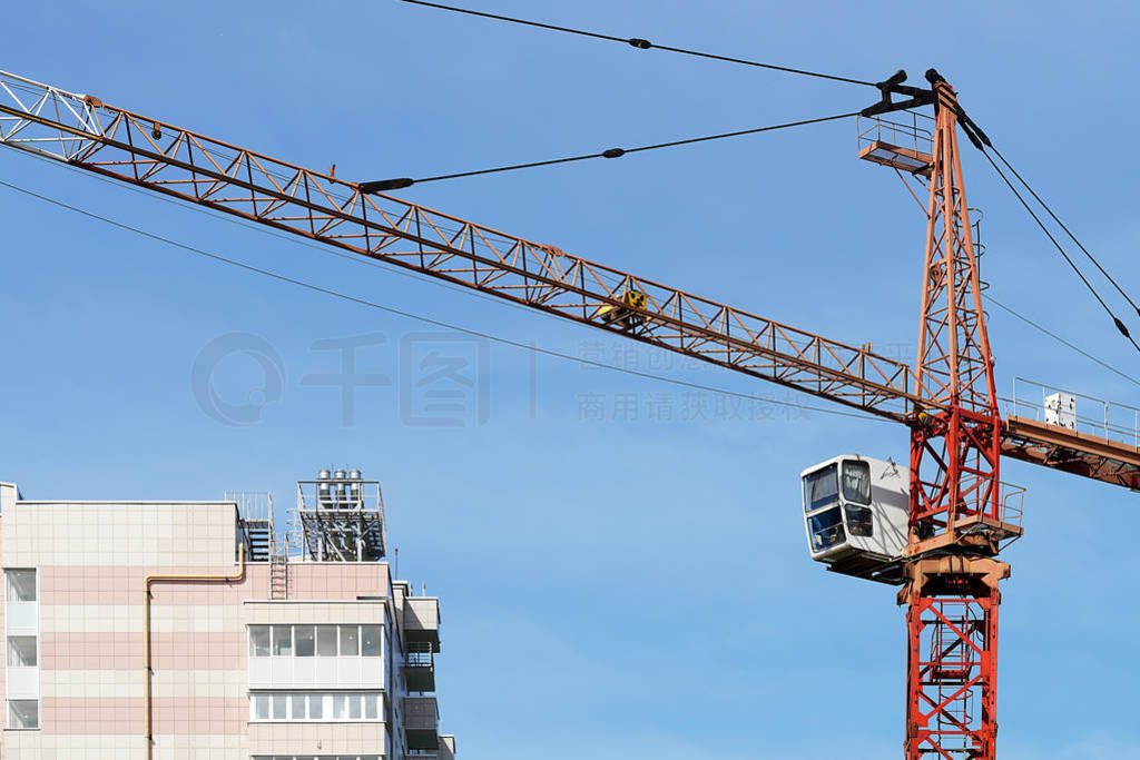 Boom crane on the construction of a high-rise building. Blue sky