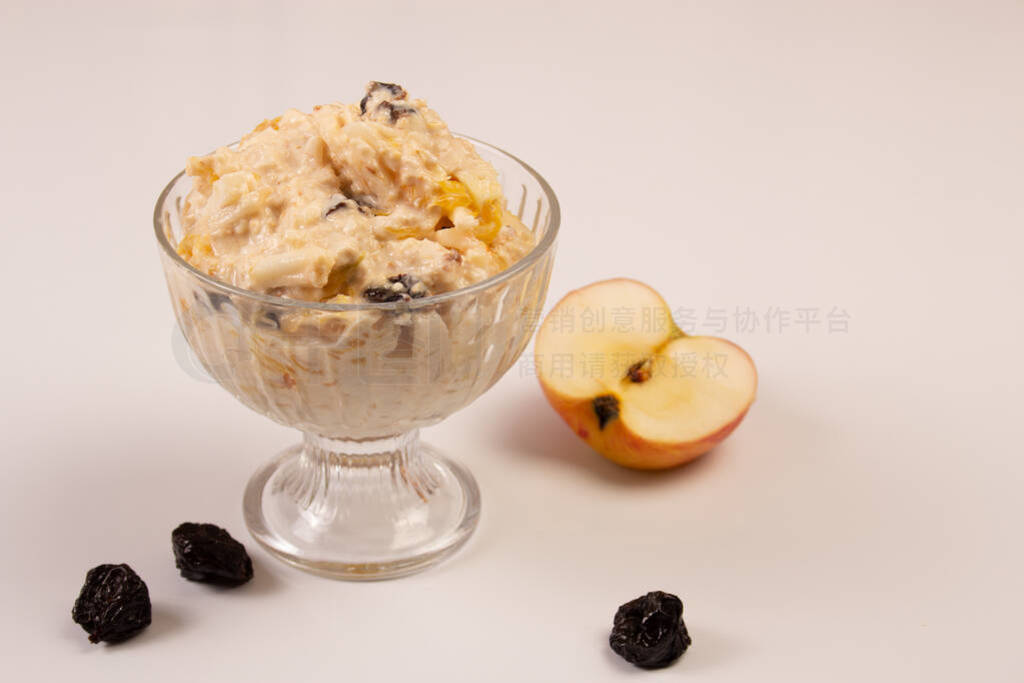 Salad of apple, orange, oat hops and prunes with honey in a glas