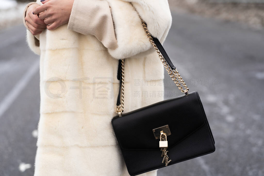 Elegant outfit. Close up of textured big dark bag. Model posing