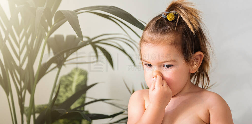 Portrait of toddler girl with finger in her nose. Bad behavior,