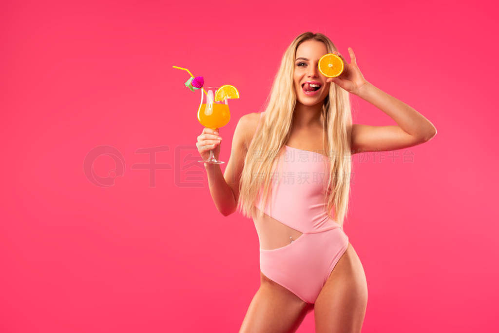 blonde girl in a bathing suit holding a cocktail in her hands
