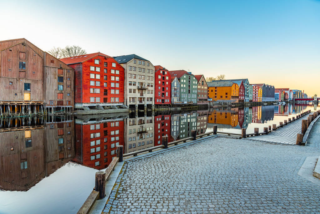 Sunset view of colorful timber houses surrounding river Nidelva