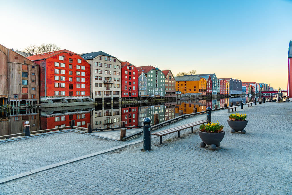 Sunset view of colorful timber houses surrounding river Nidelva