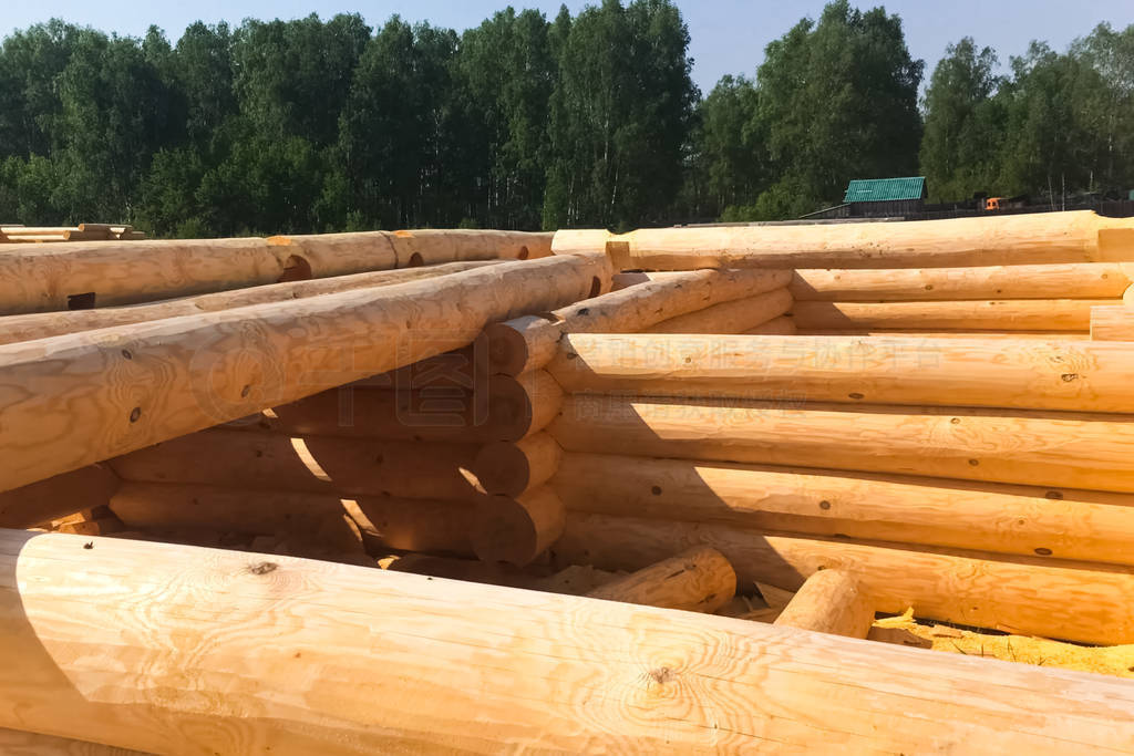 Drying and assembly of wooden log house at a construction base.