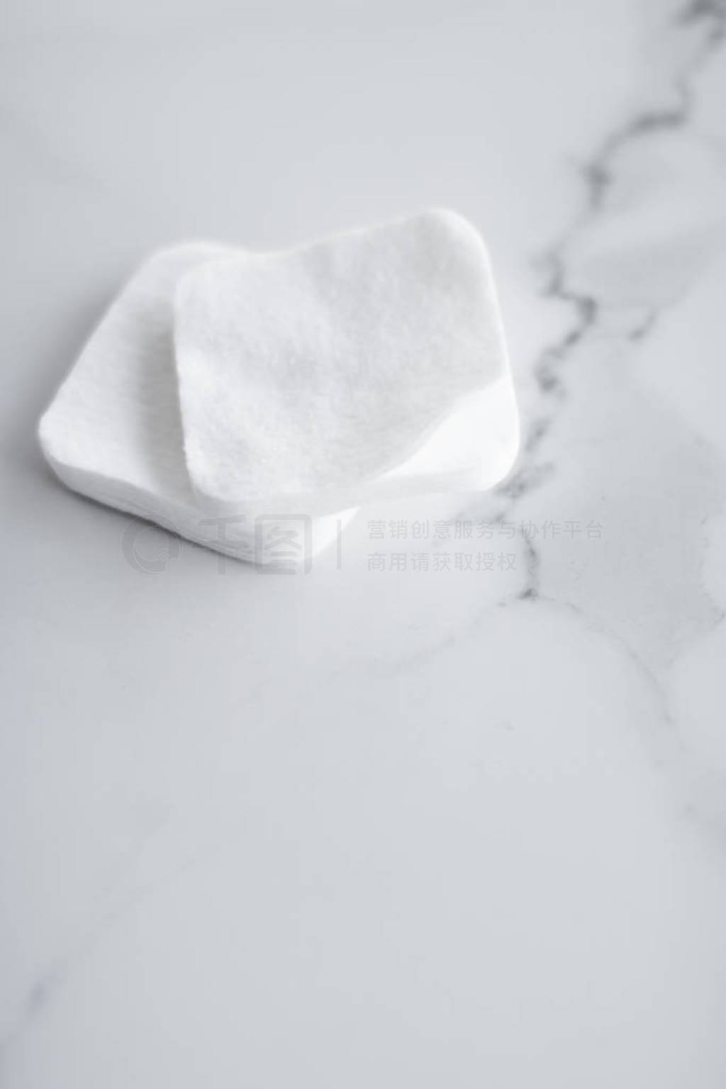 Organic cotton pads on marble background, cosmetics and make-up