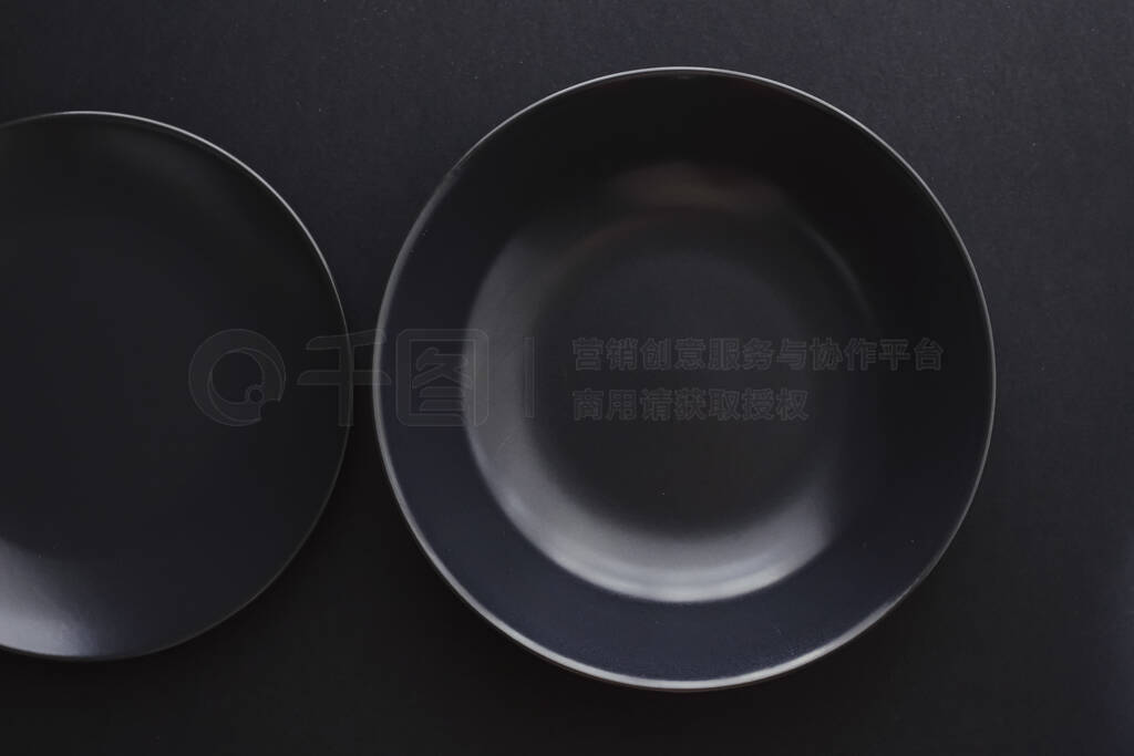 Empty plates on black background, premium dishware for holiday d