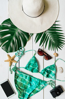 比基尼套装, 帽子, 太阳镜, 智能手机, 海星, 绿色 plam 叶子安排在木 baclground。暑假放假的概念。垂直热带