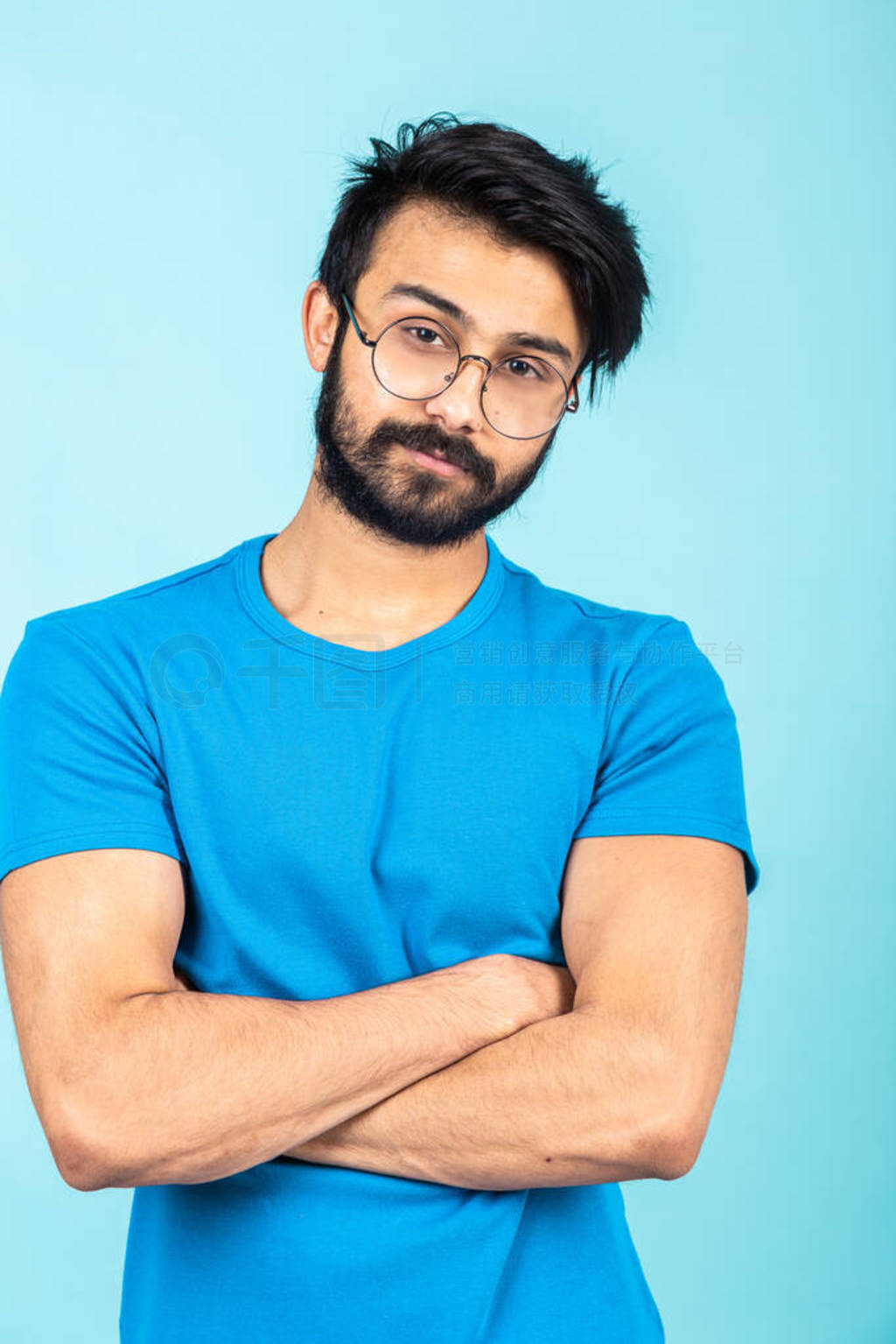 Emotional portrait of a handsome Hindu man in a blue T-shirt on