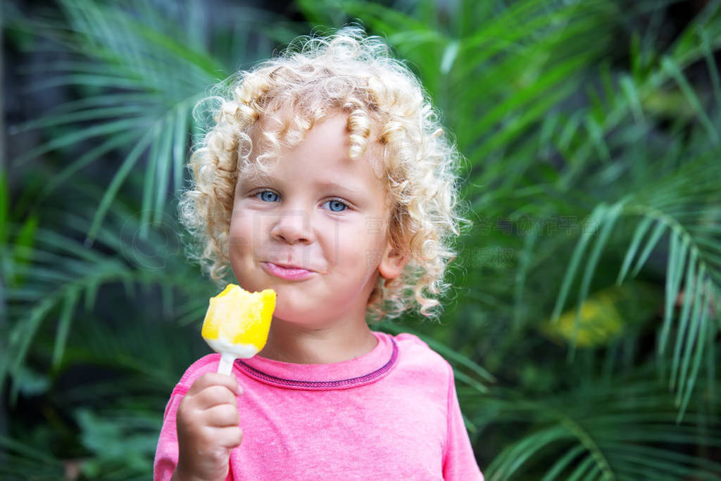 little boy with blonde curly hair is eating ice cream