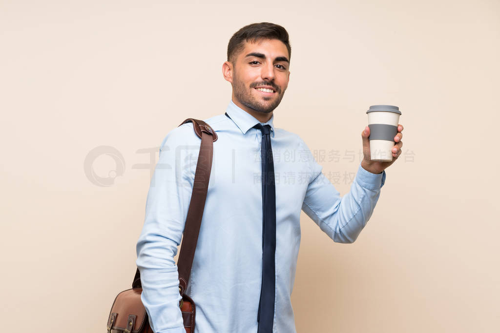 Young business with beard holding a take away coffee