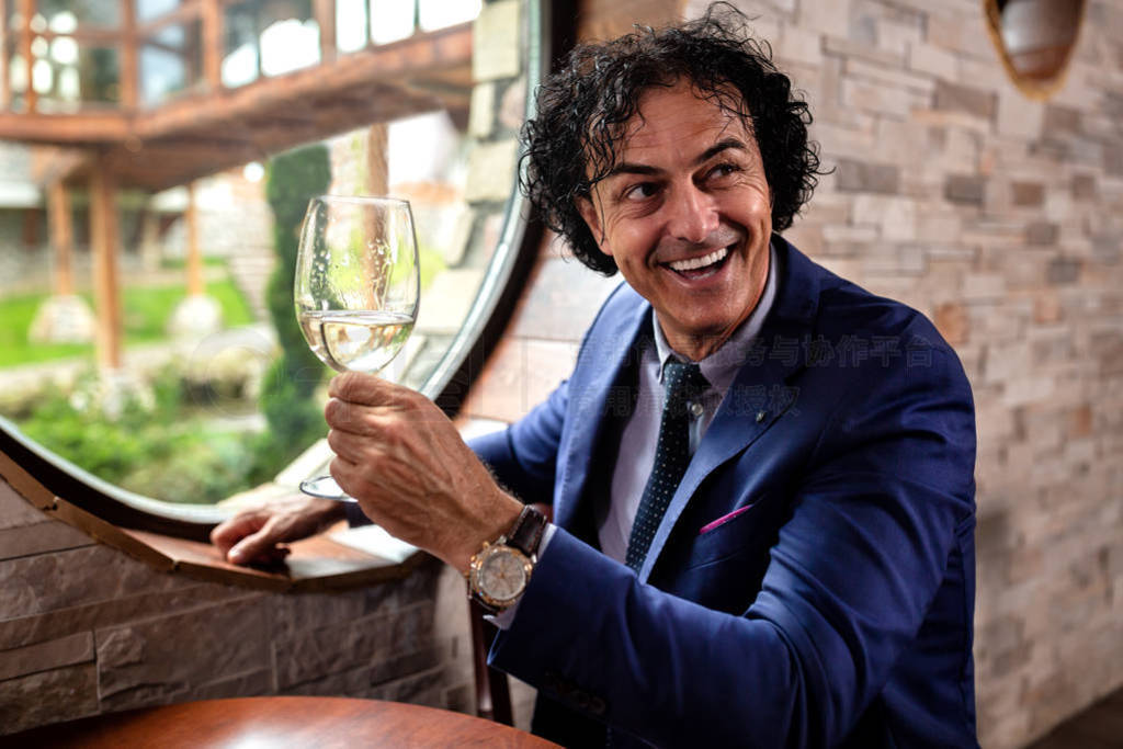 Sharp dressed man holding a glass of wine