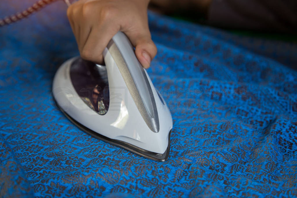 Men's hands holding steam iron