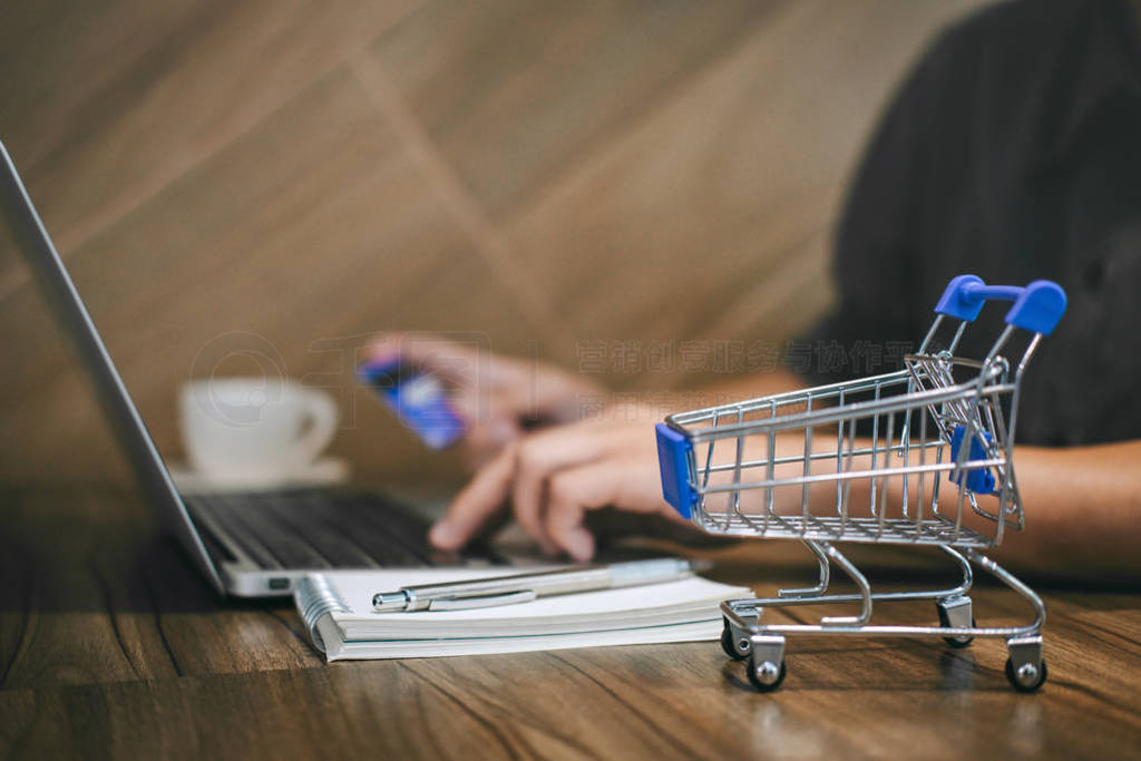 Businessman holding credit card and typing on laptop for online