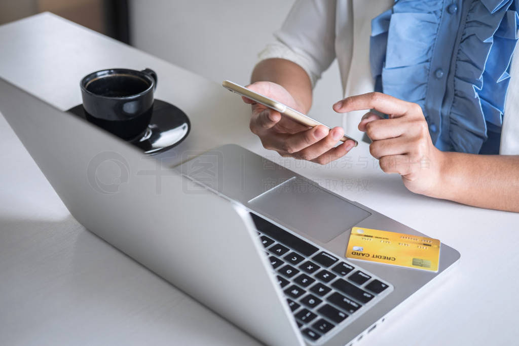 Young woman consumer holding smartphone, credit card and typing