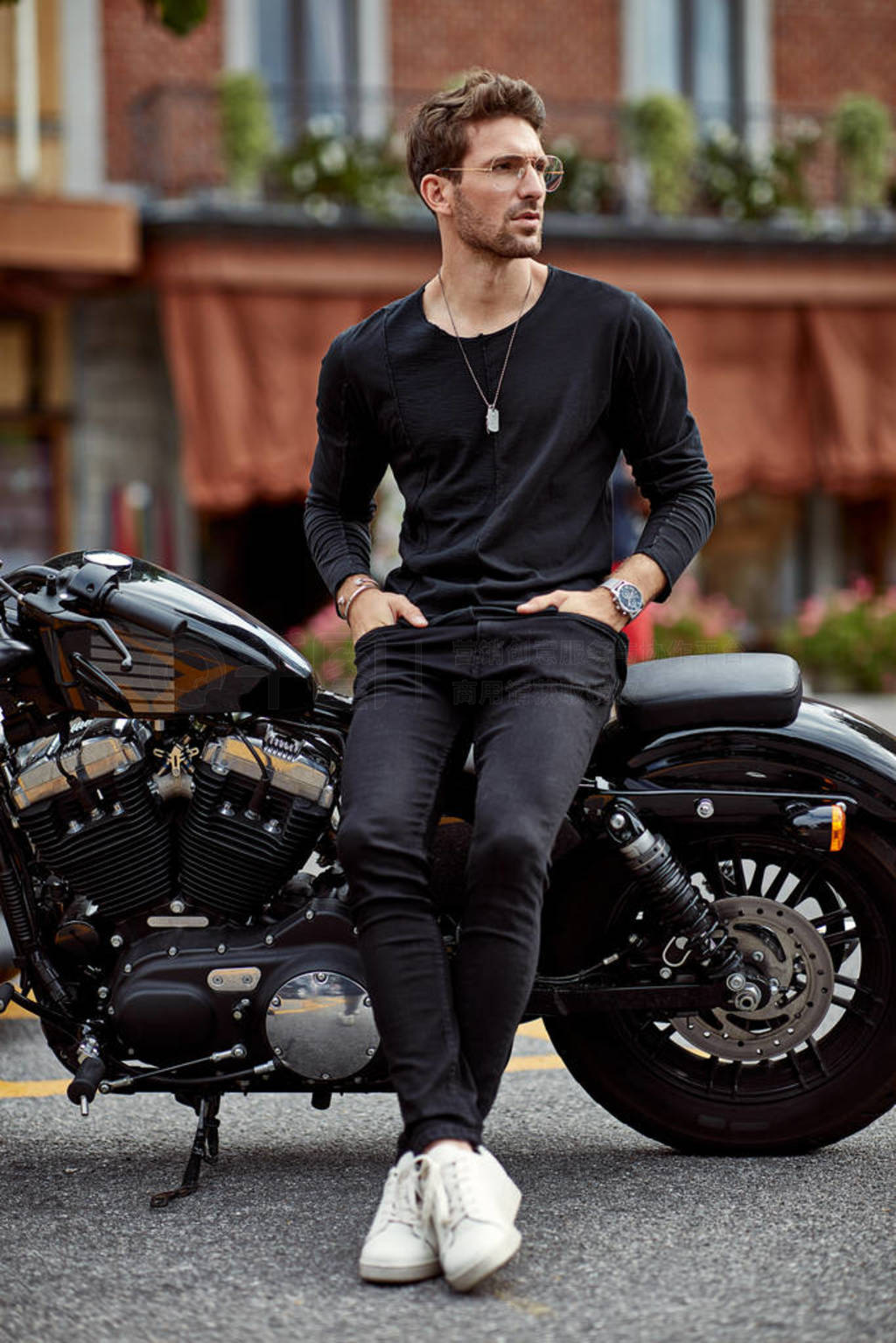 Handsome man in black sitting on american classic motorbike