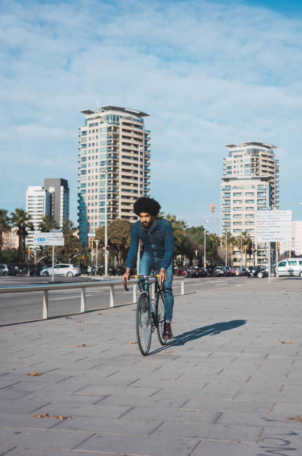 Man with afro hair riding a vintage style bicycle