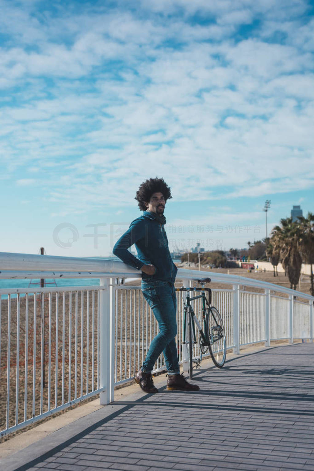 Man with afro hair riding a vintage style bicycle