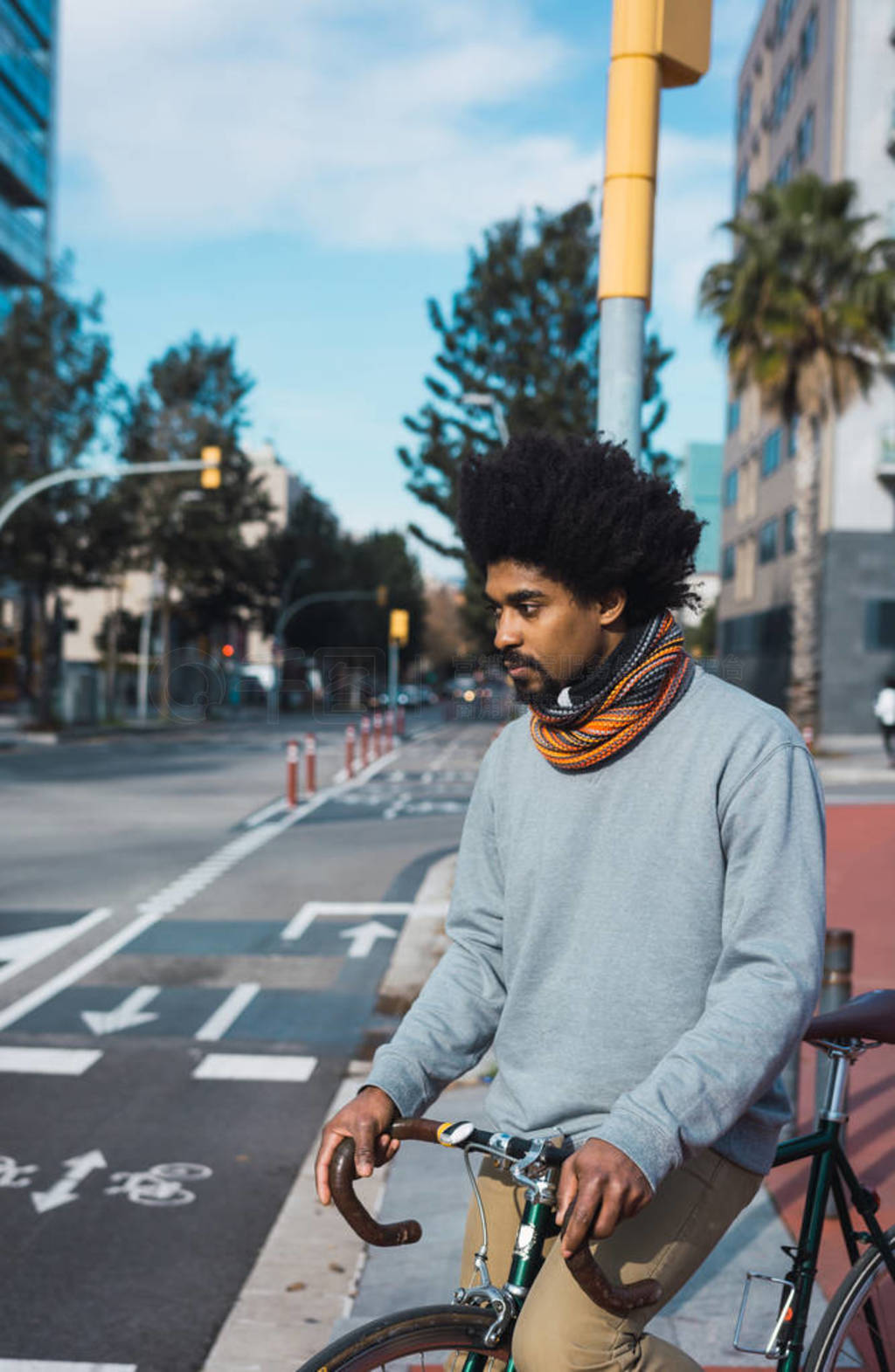 Man with afro hair riding a vintage style bicycle