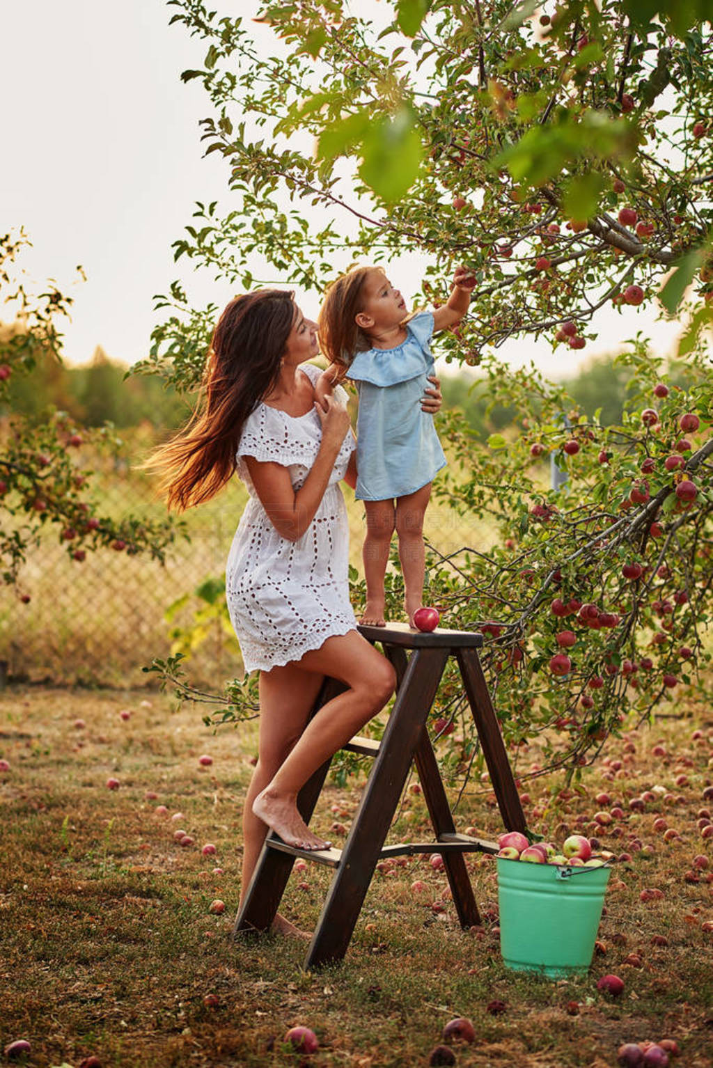 s day. Mother and daughter in apple orchard