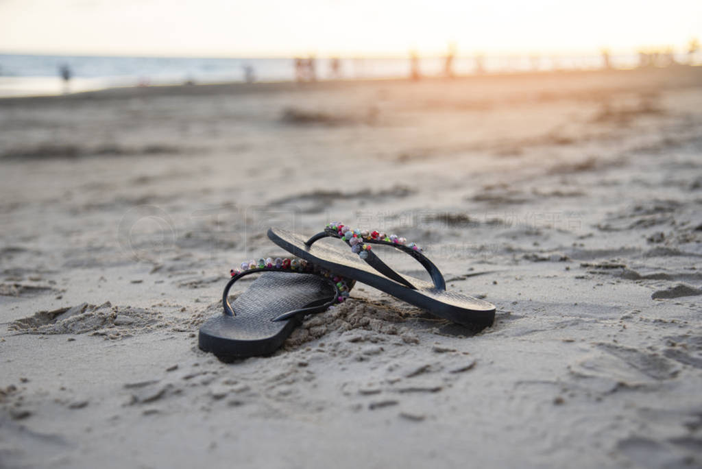 flip flops on beach with sandy beach sunset and ocean sea