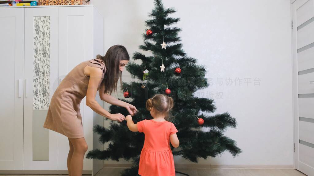 Merry Christmas and Happy Holidays. Mom and daughter decorate th