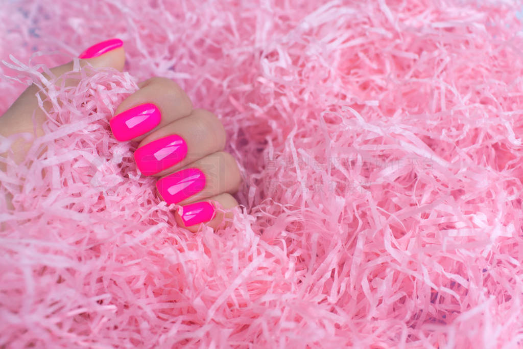 Stylish trendy female manicure. Neon plastic pink nails on confe