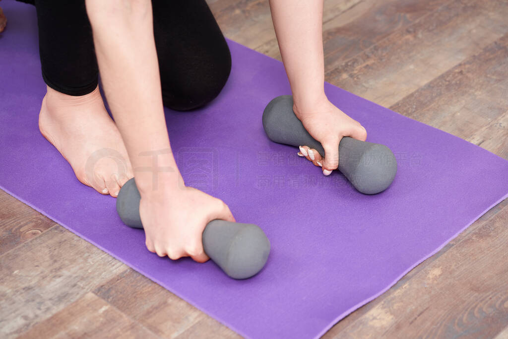 Closeup girl took dumbbells in hand for fitness at home