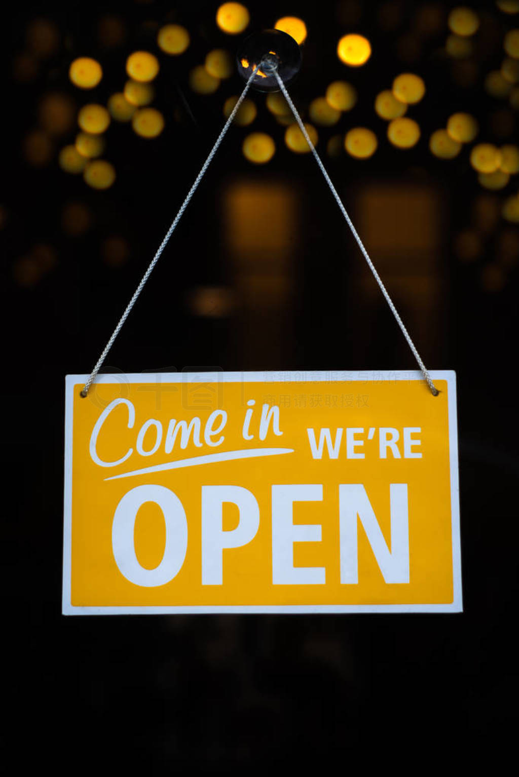 Come in We're Open Sign on a Glass Shop Door With Lights in the