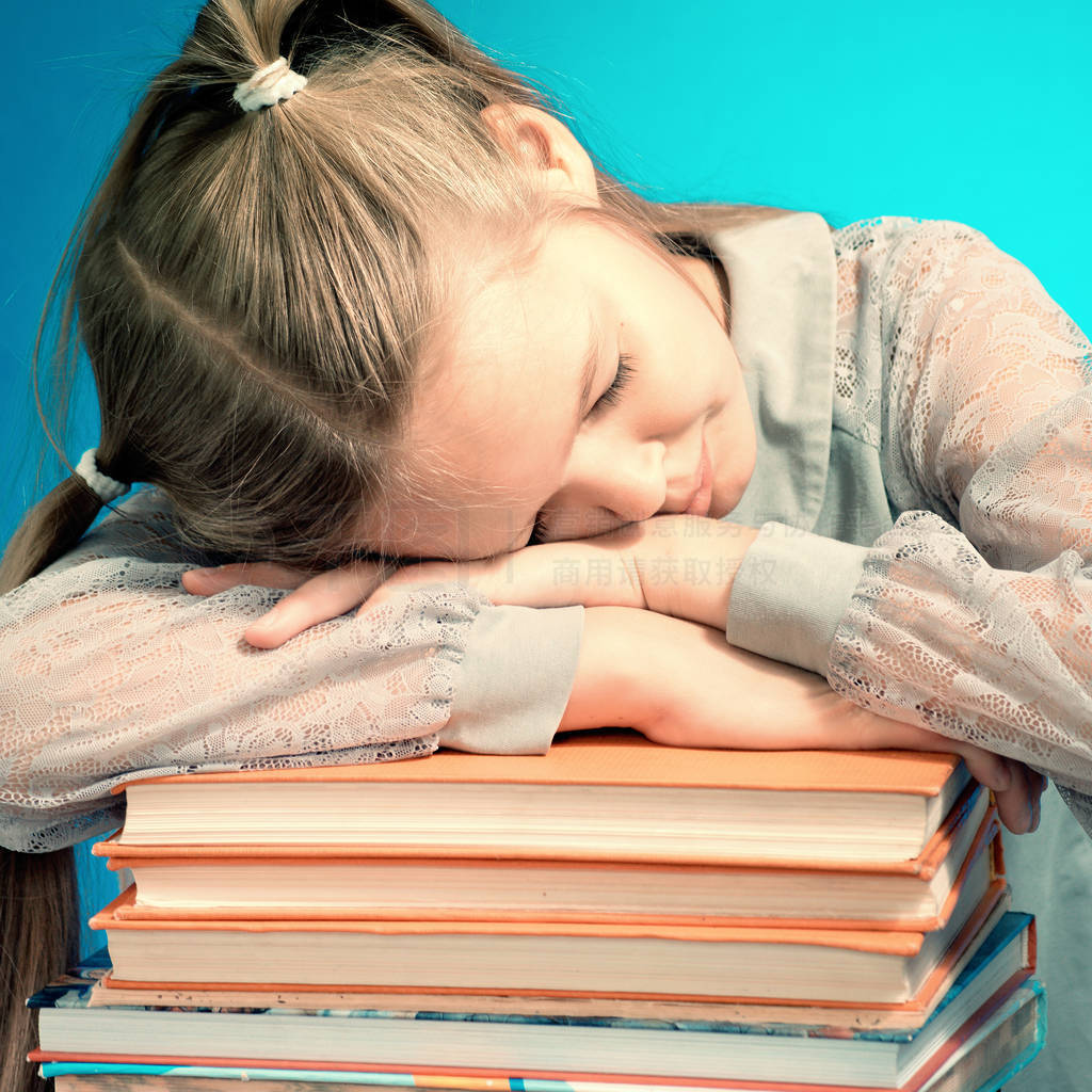 Child schoolgirl readSchoolgirl fell sleep on a stack of books.