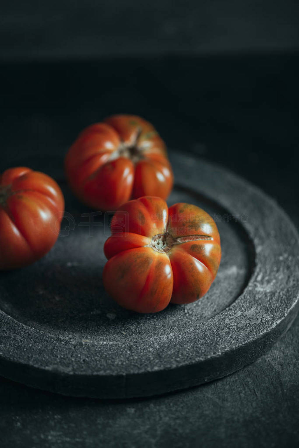 Fresh red Marmande RAF red tomatoes on concrete dish.