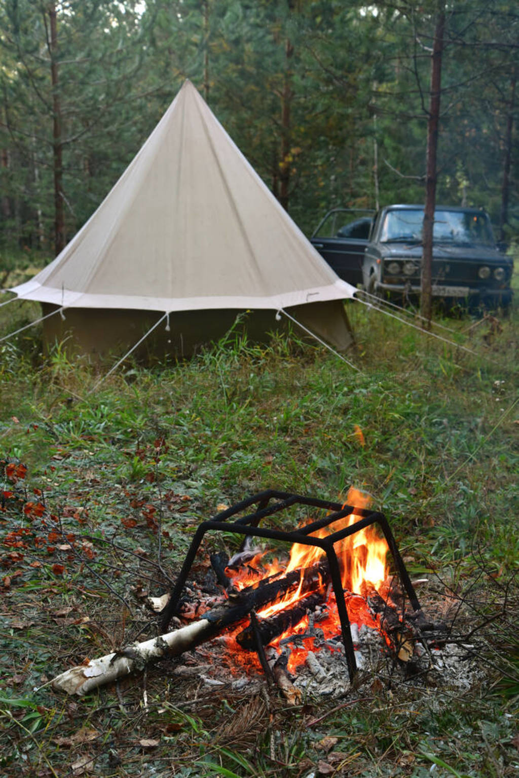 Tent and bonfire in the autumn taiga.