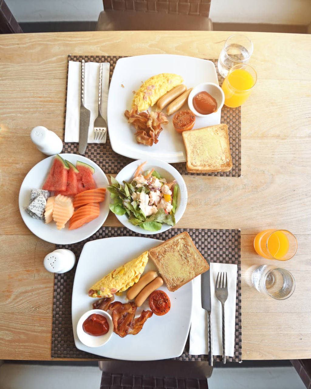 Breakfast table with fried eggs, sausages, grilled tomatoes and