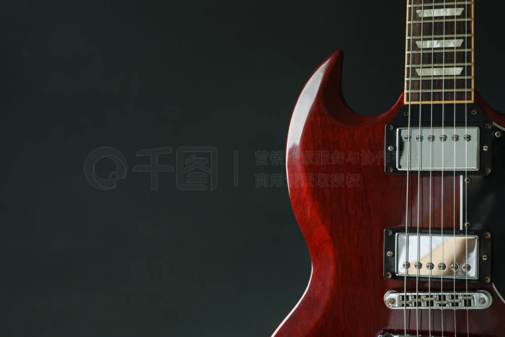 Beautiful six - string electric guitar against dark background,
