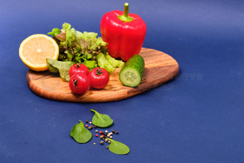 fresh vegetables and a bowl of salad with mozzarella on a blue b