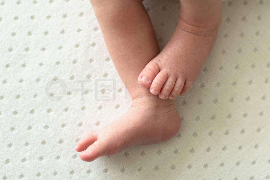 feet of the newborn baby on white background, fingers on the foo